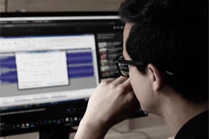 Man with glasses looking at computer screen with pop-up